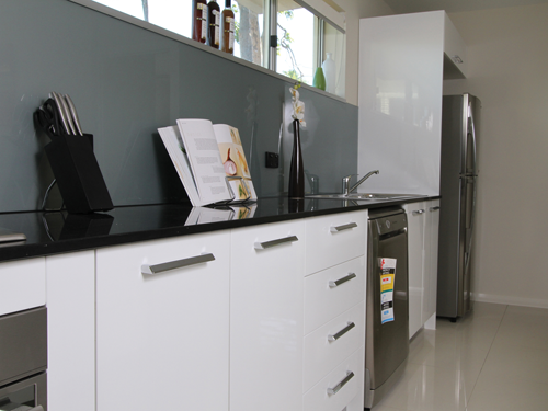 Large laundry with custom cabinets in polyurethane with built in appliances and white goods.